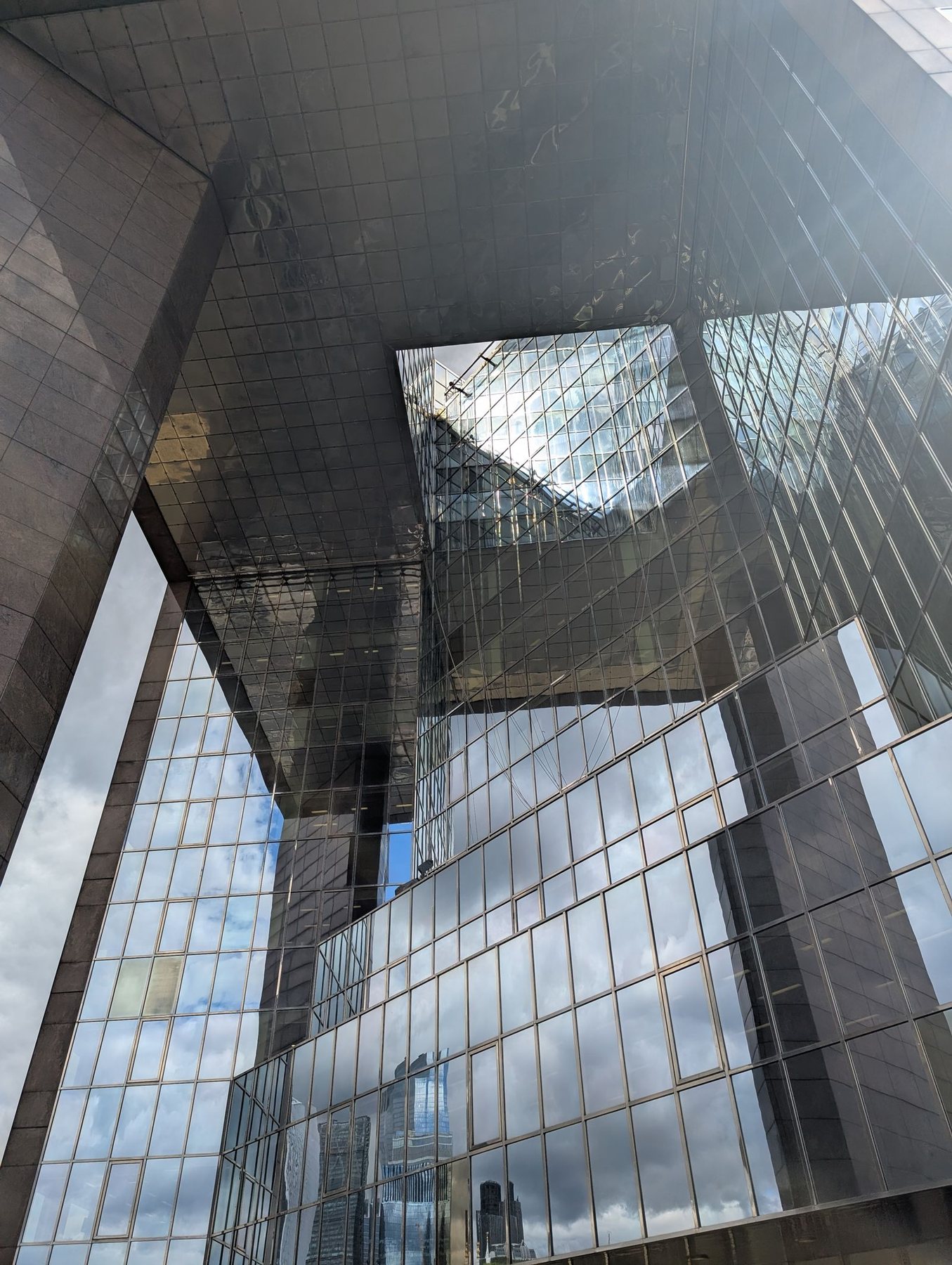 A glass tower facade reflecting the buildings around it.