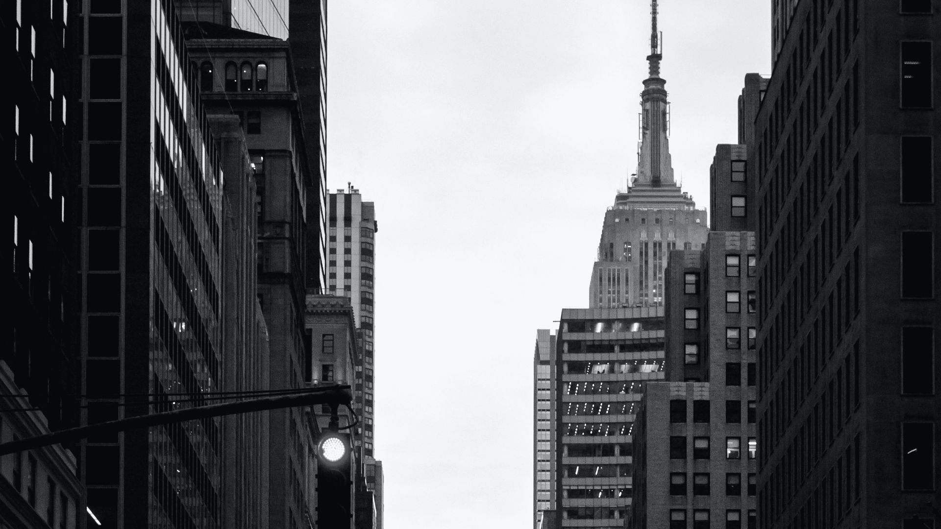 A Midtown avenue at dusk, the Empire State Building at its end.