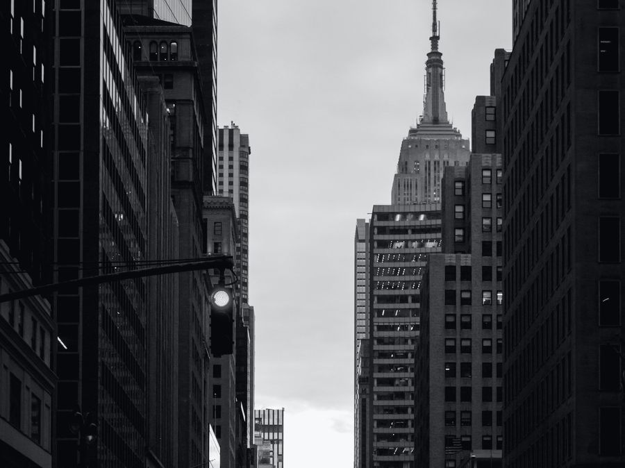 A Midtown avenue at dusk, the Empire State Building at its end.