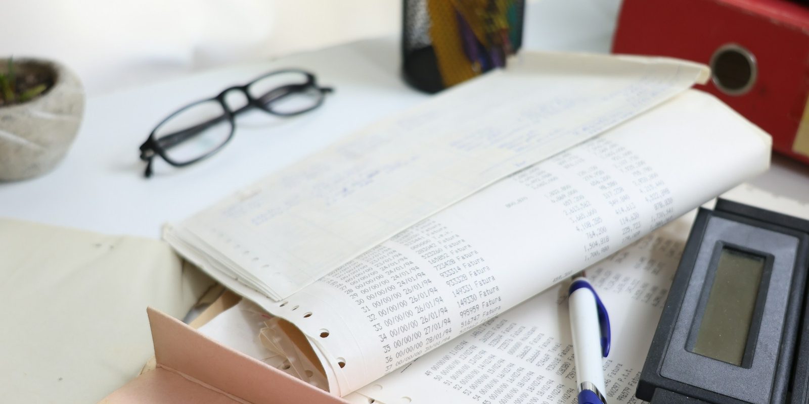 Papers, glasses and a calculator on a desk.